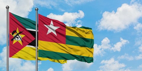 Mozambique and Togo flag waving in the wind against white cloudy blue sky together. Diplomacy concept, international relations.
