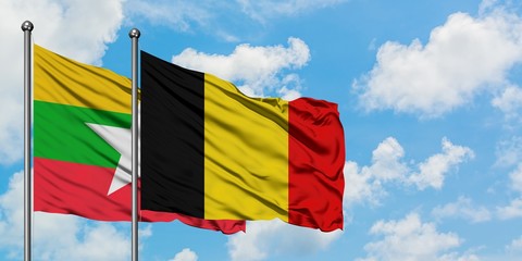 Myanmar and Belgium flag waving in the wind against white cloudy blue sky together. Diplomacy concept, international relations.