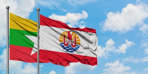 Myanmar and French Polynesia flag waving in the wind against white cloudy blue sky together. Diplomacy concept, international relations.