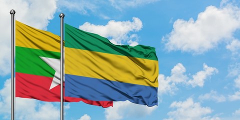 Myanmar and Gabon flag waving in the wind against white cloudy blue sky together. Diplomacy concept, international relations.