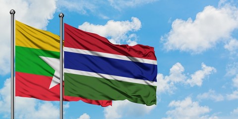 Myanmar and Gambia flag waving in the wind against white cloudy blue sky together. Diplomacy concept, international relations.