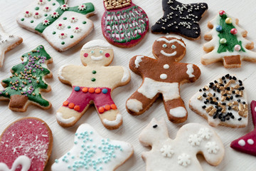 Colored icing cookies on white wood background, top view. Christmas mood concept