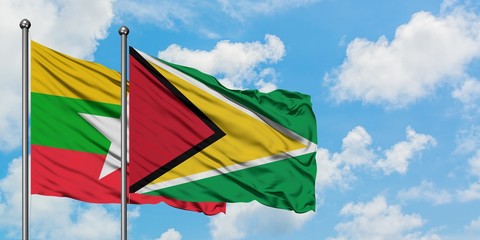Myanmar and Guyana flag waving in the wind against white cloudy blue sky together. Diplomacy concept, international relations.