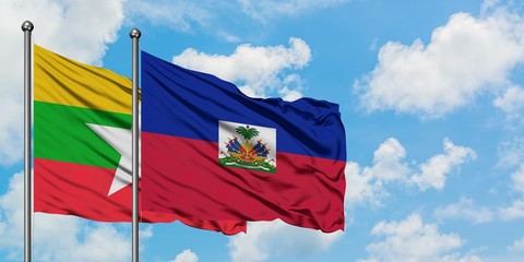 Myanmar and Haiti flag waving in the wind against white cloudy blue sky together. Diplomacy...