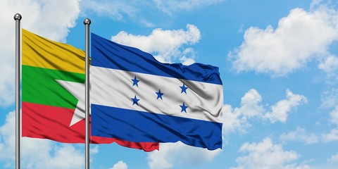 Myanmar and Honduras flag waving in the wind against white cloudy blue sky together. Diplomacy concept, international relations.