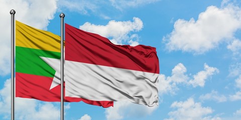 Myanmar and Indonesia flag waving in the wind against white cloudy blue sky together. Diplomacy concept, international relations.