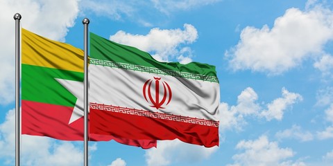 Myanmar and Iran flag waving in the wind against white cloudy blue sky together. Diplomacy concept, international relations.