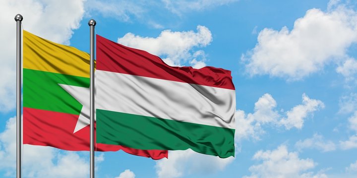 Myanmar and Hungary flag waving in the wind against white cloudy blue sky together. Diplomacy concept, international relations.