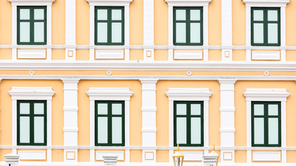 Fototapeta premium Green windows on a yellow building