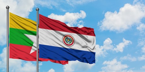 Myanmar and Paraguay flag waving in the wind against white cloudy blue sky together. Diplomacy concept, international relations.