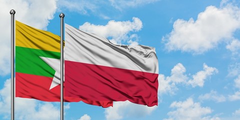 Myanmar and Poland flag waving in the wind against white cloudy blue sky together. Diplomacy concept, international relations.