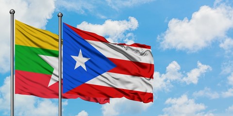 Myanmar and Puerto Rico flag waving in the wind against white cloudy blue sky together. Diplomacy concept, international relations.
