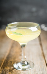 Tasty cocktail with limoncello and sage leaves on the rustic background. Shallow depth of field. Selective focus.