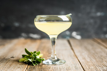 Tasty cocktail with limoncello and sage leaves on the rustic background. Shallow depth of field....