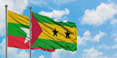 Myanmar and Sao Tome And Principe flag waving in the wind against white cloudy blue sky together....