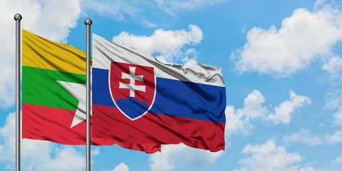 Myanmar and Slovakia flag waving in the wind against white cloudy blue sky together. Diplomacy concept, international relations.