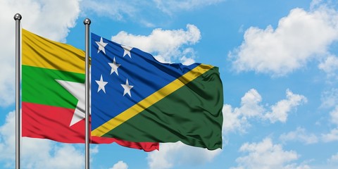 Myanmar and Solomon Islands flag waving in the wind against white cloudy blue sky together. Diplomacy concept, international relations.