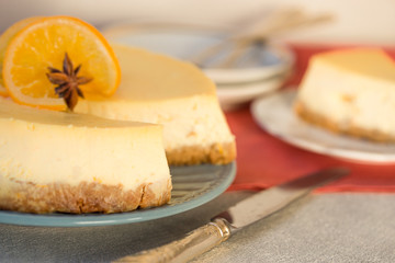 Cheesecake with slices of orange  on a gray stone background.