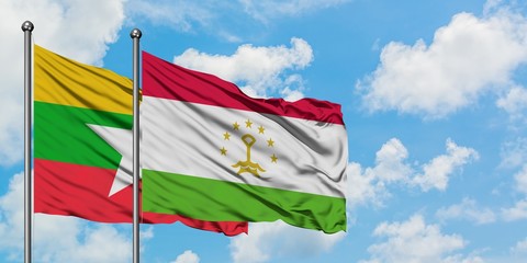Myanmar and Tajikistan flag waving in the wind against white cloudy blue sky together. Diplomacy concept, international relations.