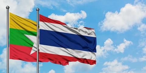 Myanmar and Thailand flag waving in the wind against white cloudy blue sky together. Diplomacy concept, international relations.