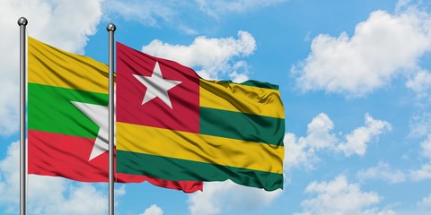 Myanmar and Togo flag waving in the wind against white cloudy blue sky together. Diplomacy concept, international relations.
