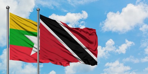 Myanmar and Trinidad And Tobago flag waving in the wind against white cloudy blue sky together. Diplomacy concept, international relations.