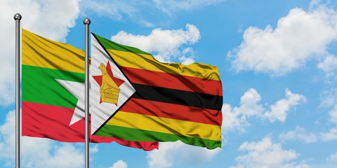 Myanmar and Zimbabwe flag waving in the wind against white cloudy blue sky together. Diplomacy concept, international relations.