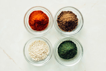 Obraz na płótnie Canvas Jars with sesame seeds, coriander, paprika and dill. Variety seasoning concept