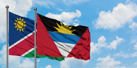 Namibia and Antigua and Barbuda flag waving in the wind against white cloudy blue sky together. Diplomacy concept, international relations.