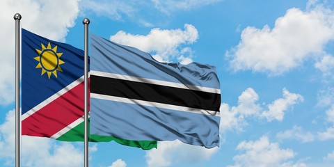 Namibia and Botswana flag waving in the wind against white cloudy blue sky together. Diplomacy concept, international relations.