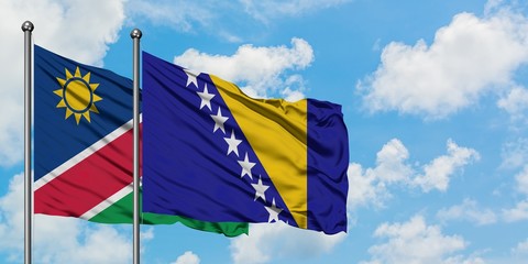 Namibia and Bosnia Herzegovina flag waving in the wind against white cloudy blue sky together. Diplomacy concept, international relations.