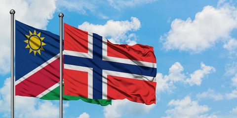 Namibia and Bouvet Islands flag waving in the wind against white cloudy blue sky together. Diplomacy concept, international relations.