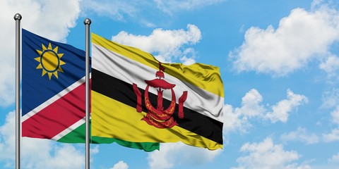 Namibia and Brunei flag waving in the wind against white cloudy blue sky together. Diplomacy concept, international relations.