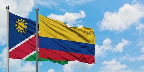 Namibia and Colombia flag waving in the wind against white cloudy blue sky together. Diplomacy concept, international relations.