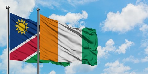 Namibia and Cote D'Ivoire flag waving in the wind against white cloudy blue sky together. Diplomacy concept, international relations.