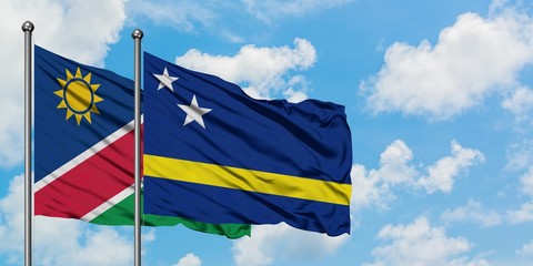 Namibia and Curacao flag waving in the wind against white cloudy blue sky together. Diplomacy concept, international relations.