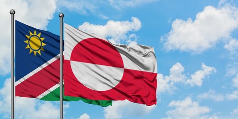 Namibia and Greenland flag waving in the wind against white cloudy blue sky together. Diplomacy concept, international relations.