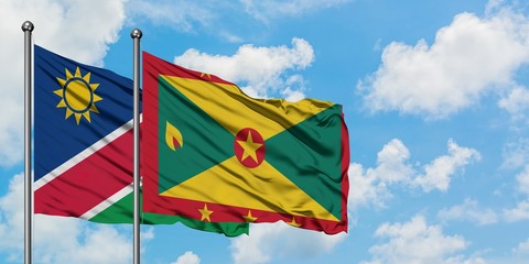 Namibia and Grenada flag waving in the wind against white cloudy blue sky together. Diplomacy concept, international relations.