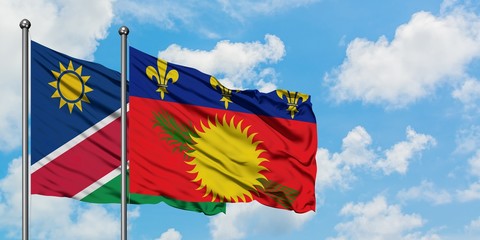 Namibia and Guadeloupe flag waving in the wind against white cloudy blue sky together. Diplomacy concept, international relations.