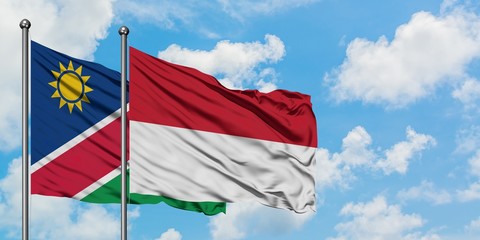 Namibia and Indonesia flag waving in the wind against white cloudy blue sky together. Diplomacy concept, international relations.