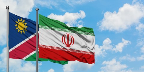 Namibia and Iran flag waving in the wind against white cloudy blue sky together. Diplomacy concept, international relations.