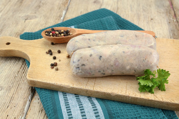 raw andouillette on a wooden board resting on a wooden table