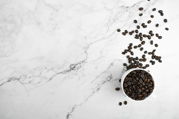 Coffee beans on a marble pattern background. Top view with copy space for your text.