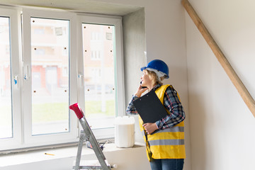 Woman Builder in the room of the house making repairs.