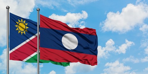 Namibia and Laos flag waving in the wind against white cloudy blue sky together. Diplomacy concept, international relations.