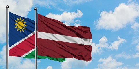 Namibia and Latvia flag waving in the wind against white cloudy blue sky together. Diplomacy concept, international relations.