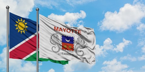 Namibia and Mayotte flag waving in the wind against white cloudy blue sky together. Diplomacy concept, international relations.