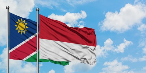 Namibia and Monaco flag waving in the wind against white cloudy blue sky together. Diplomacy concept, international relations.