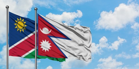 Namibia and Nepal flag waving in the wind against white cloudy blue sky together. Diplomacy concept, international relations.