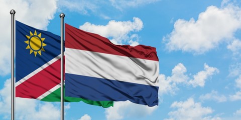 Namibia and Netherlands flag waving in the wind against white cloudy blue sky together. Diplomacy concept, international relations.